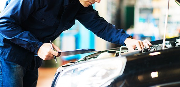 Mechanic-With-Clipboard-Examining-Car Mechanic-With-Clipboard-Examining-Car